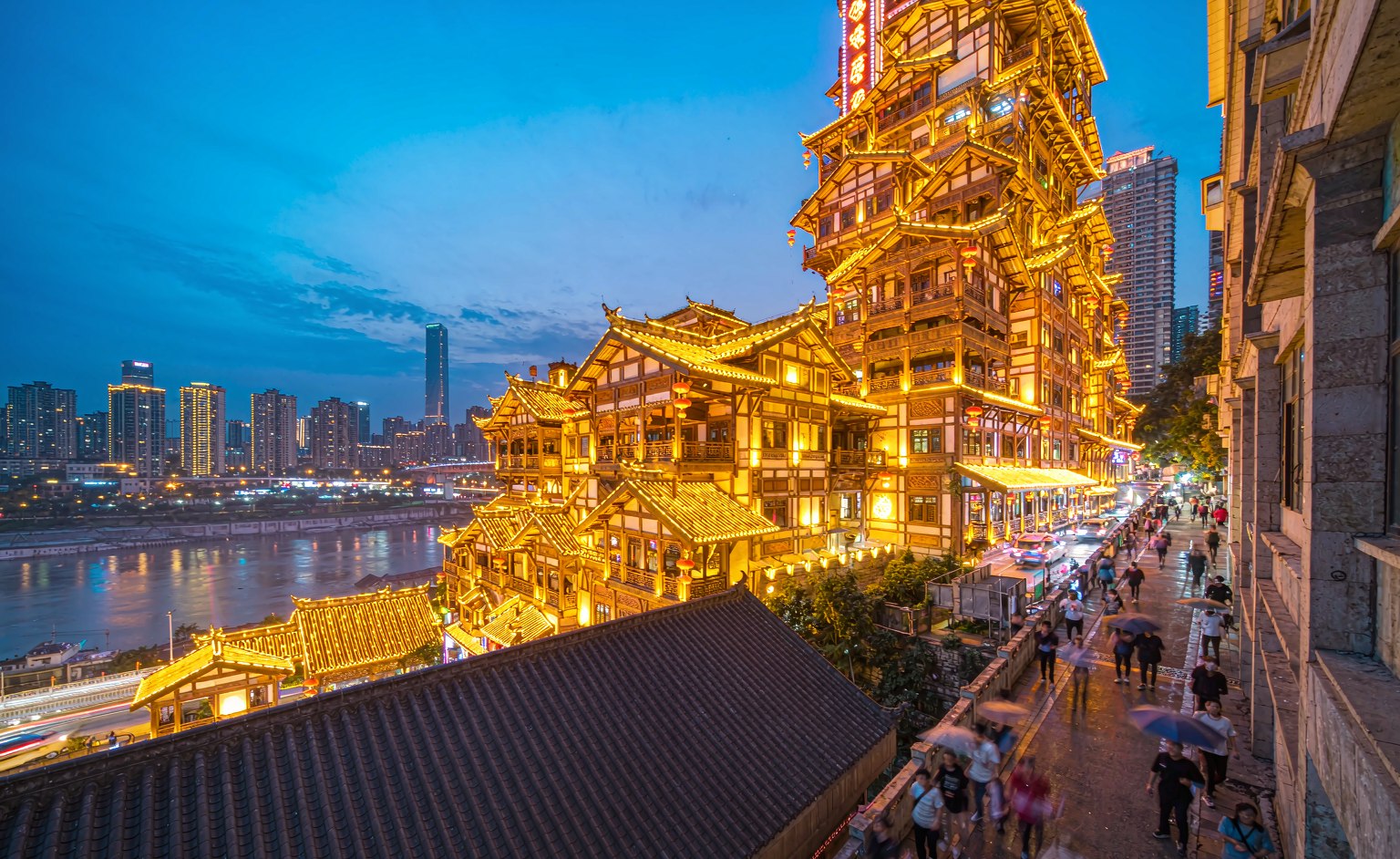 The Hongyadong stilt-house complex lit up golden at dusk beside the Jialing river