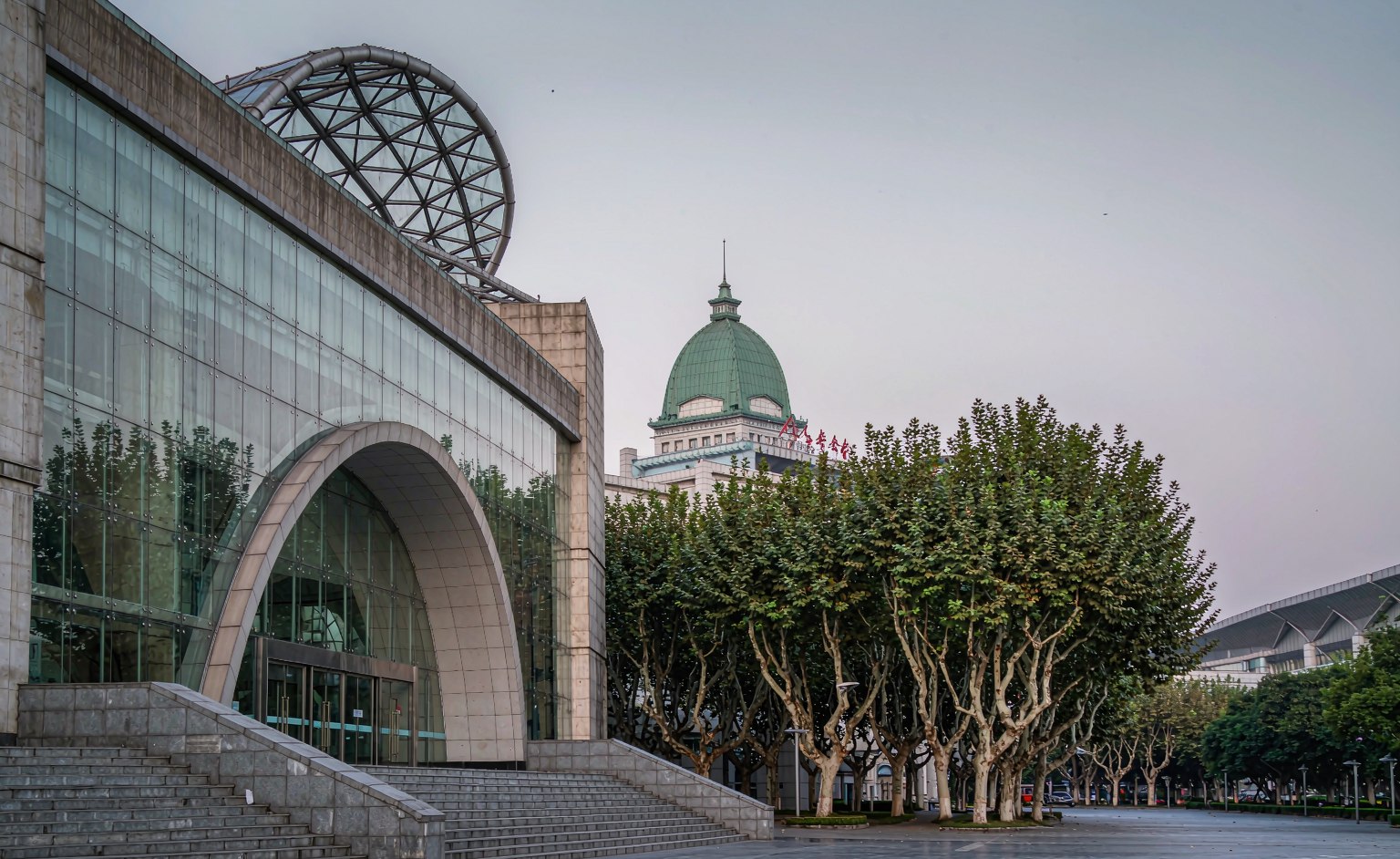 The curved glass and stone facade of the Three Gorges Museum and its empty plaza